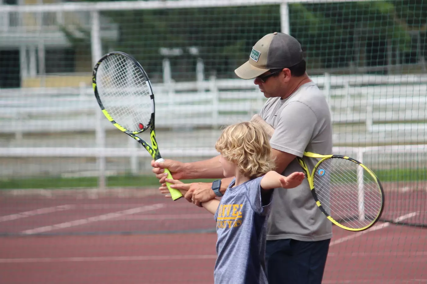 Ramse Hoehn, tennis director, works with a tennis camper