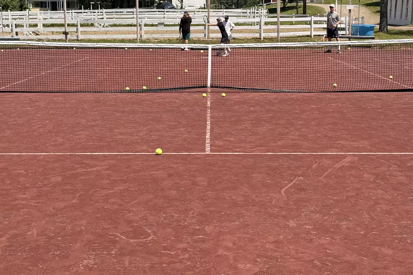 A tennis player hitting with the ball machine