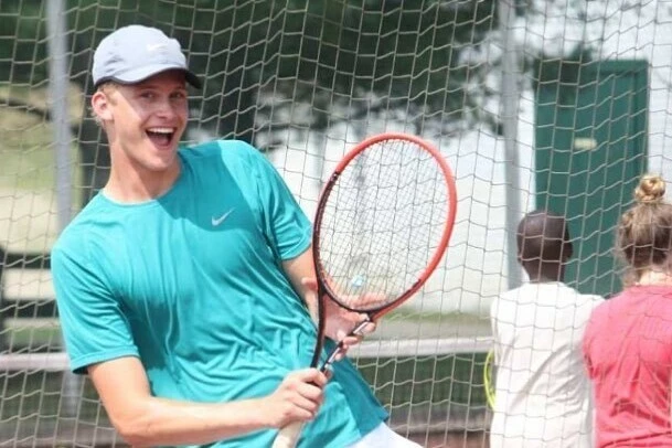 smiling with tennis racket