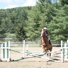 camper riding a horse jumping