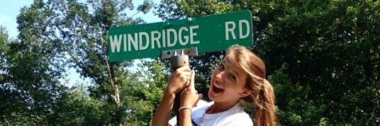 happy camper hugging windridge road sign